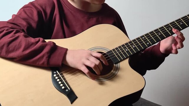 Teen boy playing guitar, music lesson concept and hobbies