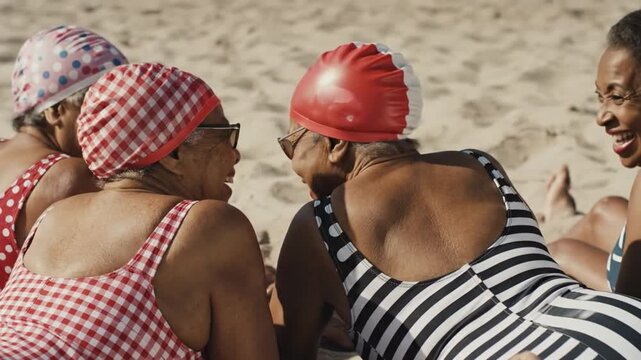 Senior women in vintage swimsuits relaxing on the beach. Lifestyle.
