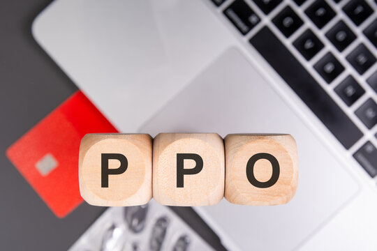 PPO acronym on wooden cubes with credit card pills and laptop