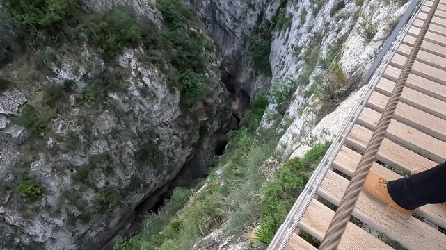 Hombre asom&aacute;ndose al vac&iacute;o en la pasarela de Relleu