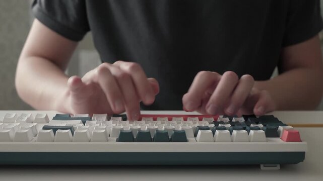 Hands typing diligently. Focused keyboard work activity. Precise finger movements on keyboard in quiet environment. Individual maintaining steady rhythm while coding in dimly lit home office setting