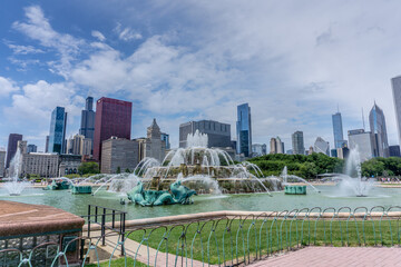 Fototapeta premium The fountain is surrounded by a green park and a fence