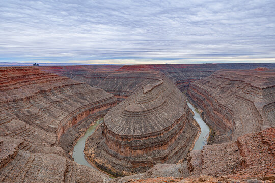 A wide-angle, panoramic view of the deep, winding entrenched meanders of the San Juan River carved into the desert landscape at Goosenecks State Park,