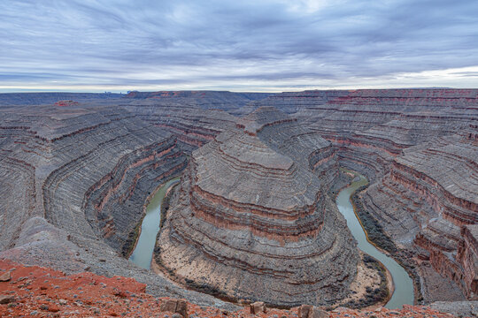 A wide-angle, panoramic view of the deep, winding entrenched meanders of the San Juan River carved into the desert landscape at Goosenecks State Park