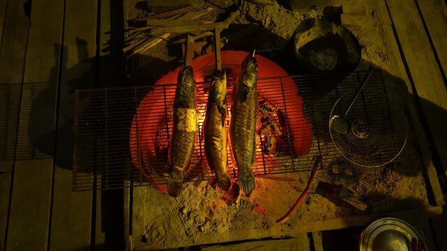 Fresh fish grilling over open wood fire