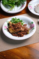 Delicious traditional chicken dish with herbs on floral plate