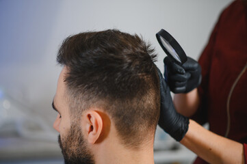 Fototapeta premium Doctor examining patient's head for moles and skin issues