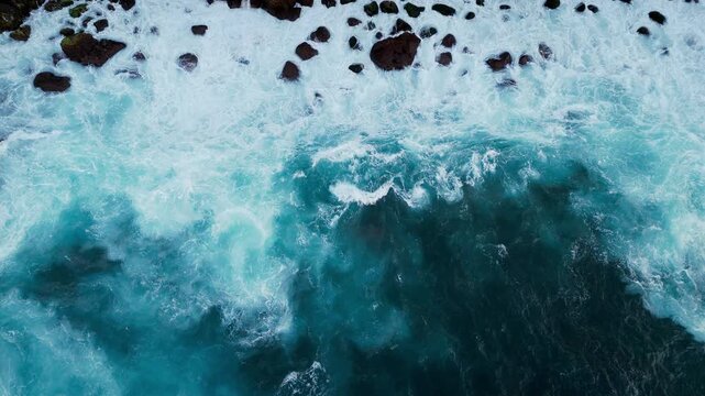 Top down aerial view of ocean waves breaking over rocks and reef in the Atlantic Ocean