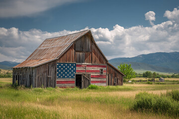 Obraz premium A rustic barn with an American flag painted on its side standing in an open countryside field.