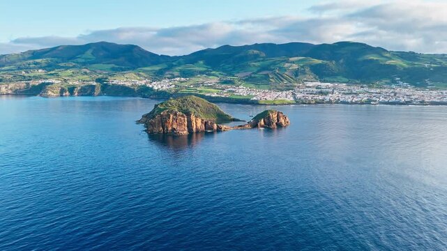 Volcanic islet near Vila Franca do Campo with layered rock walls and emerald lagoon, aerial view