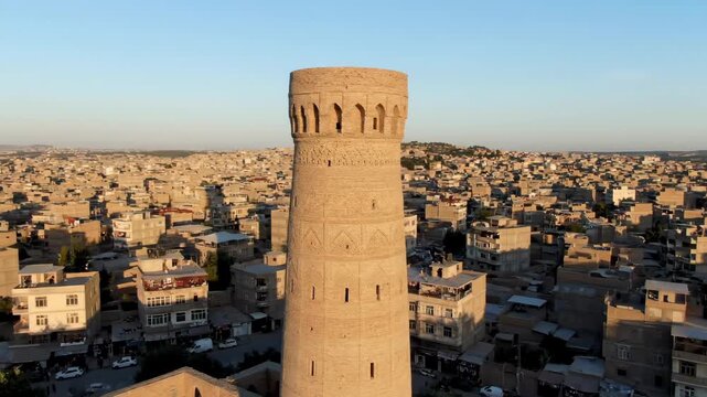 Ancient minaret tower overlooking the historic city of herat in afghanistan. Panoramic cityscape view of a middle eastern urban landscape at golden hour sunset