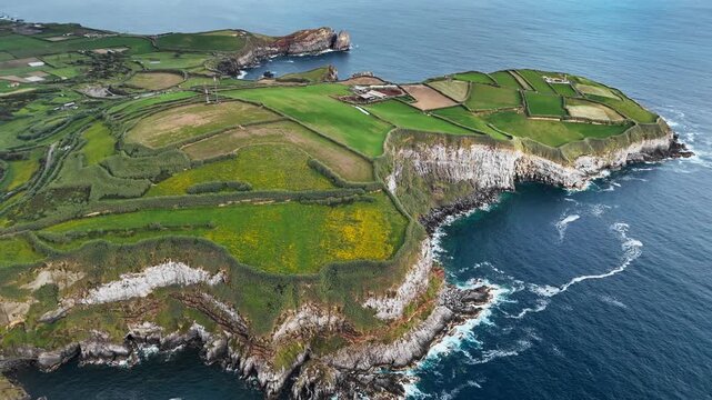 Agricultural patchwork landscape along rocky Atlantic shore in Azores, Portugal. Aerial view