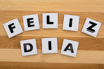 Happy Day text in spanish and background wooden blocks. New year is the first day of the year in the Gregorian calendar.