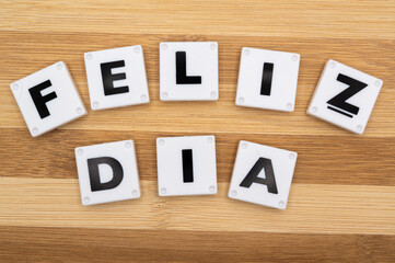 Happy Day text in spanish and background wooden blocks. New year is the first day of the year in the Gregorian calendar.