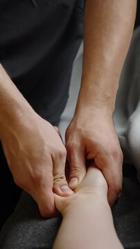 Close-up of professional therapist performing focused palm massage and acupressure, applying firm thumb pressure to relieve tension and promote relaxation in a calm wellness setting