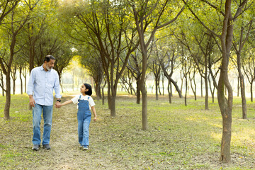 Fototapeta premium Indian happy senior man walking with granddaughter at park