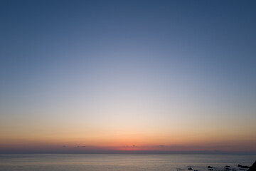 Fototapeta premium Vast open sea under a clear gradient sky at dusk, soft pastel colors blending above calm water with a tranquil horizon in Kushimoto, Japan.