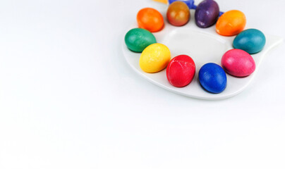 Obraz premium Colorful dyed easter eggs arranged on duck plate, isolated on white background with copy space
