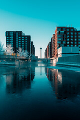 Fototapeta premium Cinematic winter canal between modern buildings in Tampere, Finland