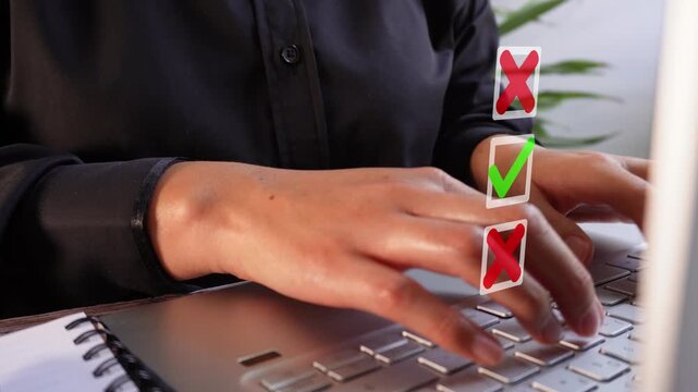 Close-up of a businesswoman working on her computer with an animation of several selection boxes, one with a checkmark and two with an X.