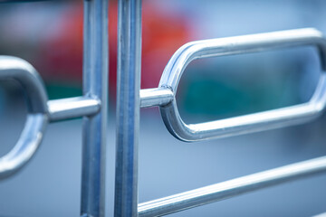 Close-up of the metal railing of a shopping cart. Shallow depth of field