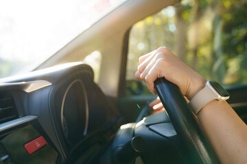 Fototapeta premium Close up of hand on steering wheel with smartwatch