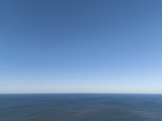 Obraz premium Clear blue sky above calm ocean water during midday