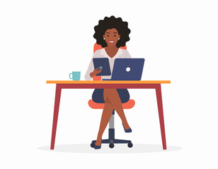 Fototapeta premium A young woman works on her laptop and tablet at her office desk with a coffee mug nearby