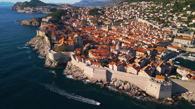 High altitude aerial pull-away of Dubrovnik Old Town. Cinematic 4K drone rotation revealing the entire fortress and Adriatic coast.