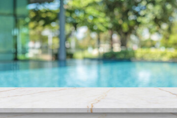 Empty marble table top with blur outdoor swimming pool in tropical resort hotel summer background © Kwangmoozaa