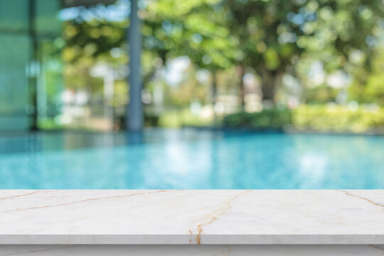 Empty marble table top with blur outdoor swimming pool in tropical resort hotel summer background