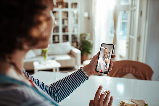 Woman having telehealth video call with doctor at home