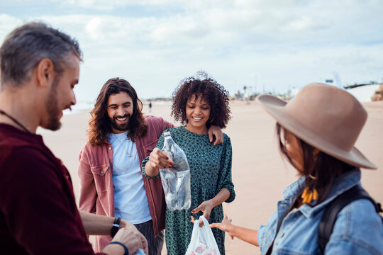 Group of friends cleaning plastic trash on beach