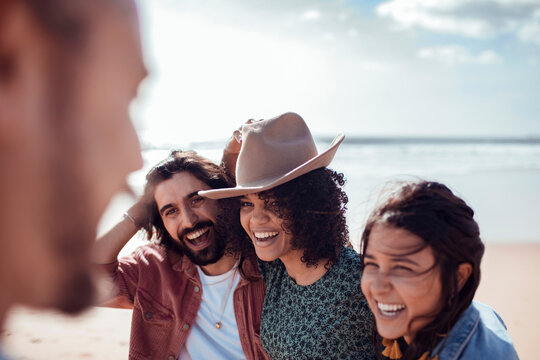Young friends laughing together at the beach