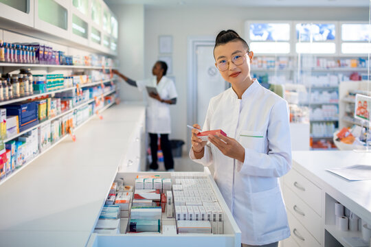 Pharmacists checking medication inventory in retail pharmacy