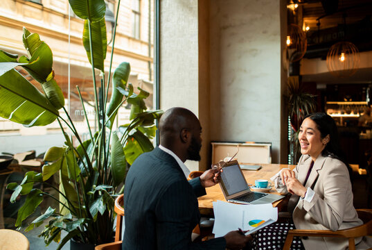 Colleagues discussing marketing report in modern cafe