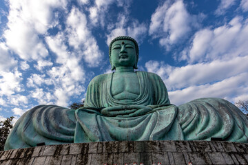 Obraz premium The backdrop of Thailand's Wat Phra That Doi Phra Chan tourist attraction in Lampang, high on a mountain, features a large Japanese-style Buddha statue that tourists can publicly photograph.