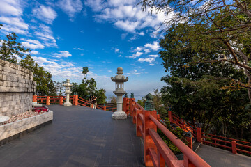 Naklejka premium The backdrop of Thailand's Wat Phra That Doi Phra Chan tourist attraction in Lampang, high on a mountain, features a large Japanese-style Buddha statue that tourists can publicly photograph.