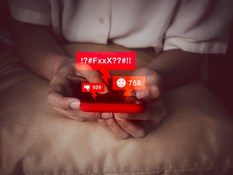 Concept of cyberbullying and online harassment through mobile phone, showing hateful messages, angry reactions, and social media negativity. Represents mental health risk in digital communication.