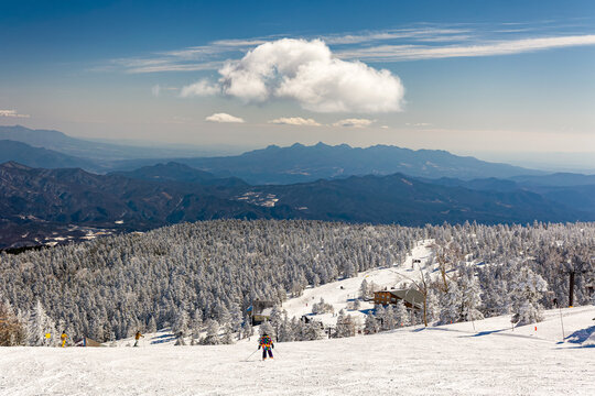 Panoramic winter view of ski resort with frozen trees and mountain range
