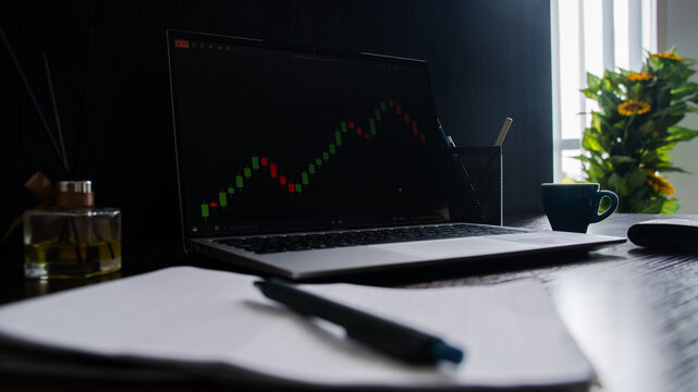Stock market trading chart on laptop screen in modern workspace