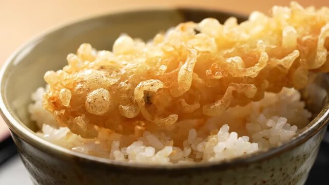 Close-up of Ebi Tempura Donburi (Tendon) with crispy fried shrimp on a bed of fluffy steamed white rice, a traditional Japanese meal served in a ceramic bowl.