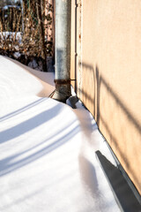 Winter Snow Around Exterior Wall And Metal Drainpipe