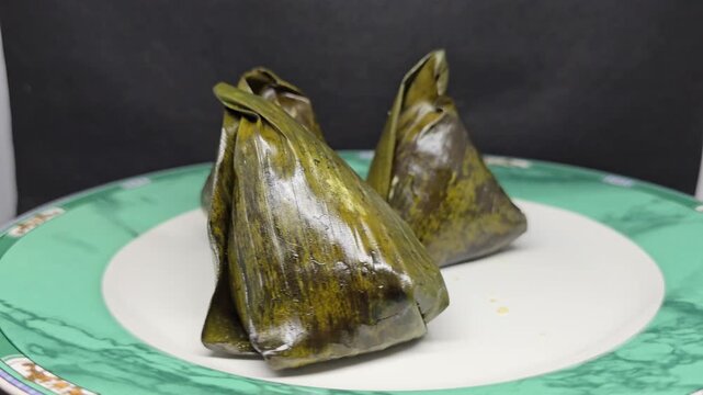Traditional indonesian koci dumplings pyramid shaped banana leaf parcels filled with sweet coconut palm sugar, steamed glutinous rice dessert showcasing authentic southeast asian cuisine