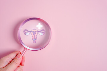 Preventive women health concept with uterus illustration under magnifying glass on pink background...