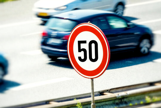 Eine Stra&szlig;e mit vorbeifahrenden Autos und Schild Tempolimit 50