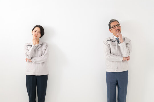 考える作業服を着た男女