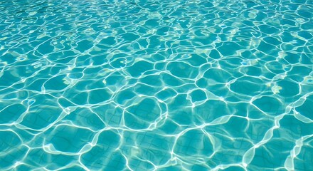 Obraz premium Crystal clear blue water surface in swimming pool with sun reflection and ripples for summer resort and luxury vacation background