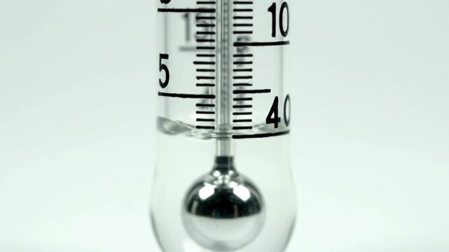 Close-up of a scientific glass thermometer or hydrometer with liquid and scale markings, representing measurement and precision.