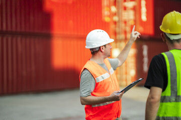Port terminal supervisor reviewing shipment checklist and directing logistics worker. Global trade...